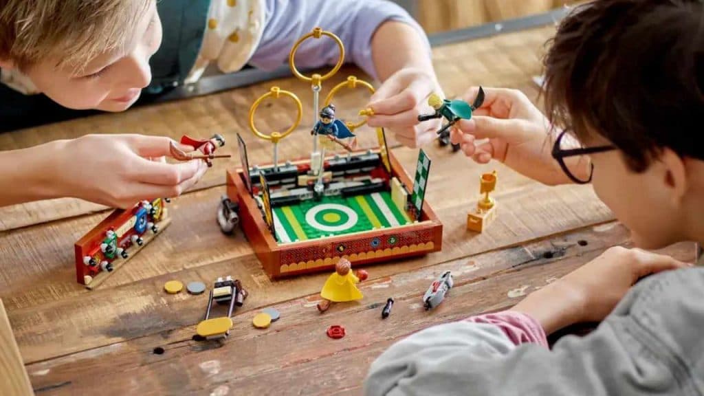 Two kids playing with the LEGO Harry Potter Quidditch Trunk set