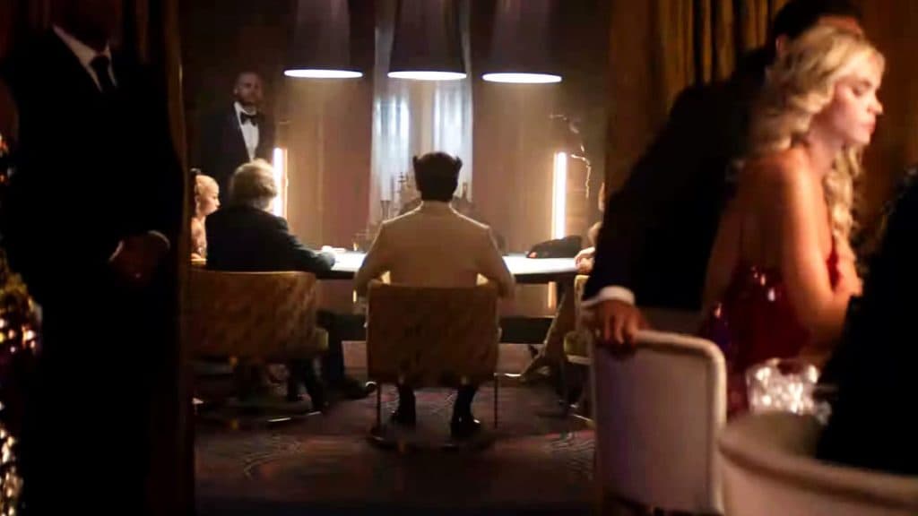 An unknown actor dressed as Patch in the Deadpool trailer, wearing a white suit and facing away from the camera
