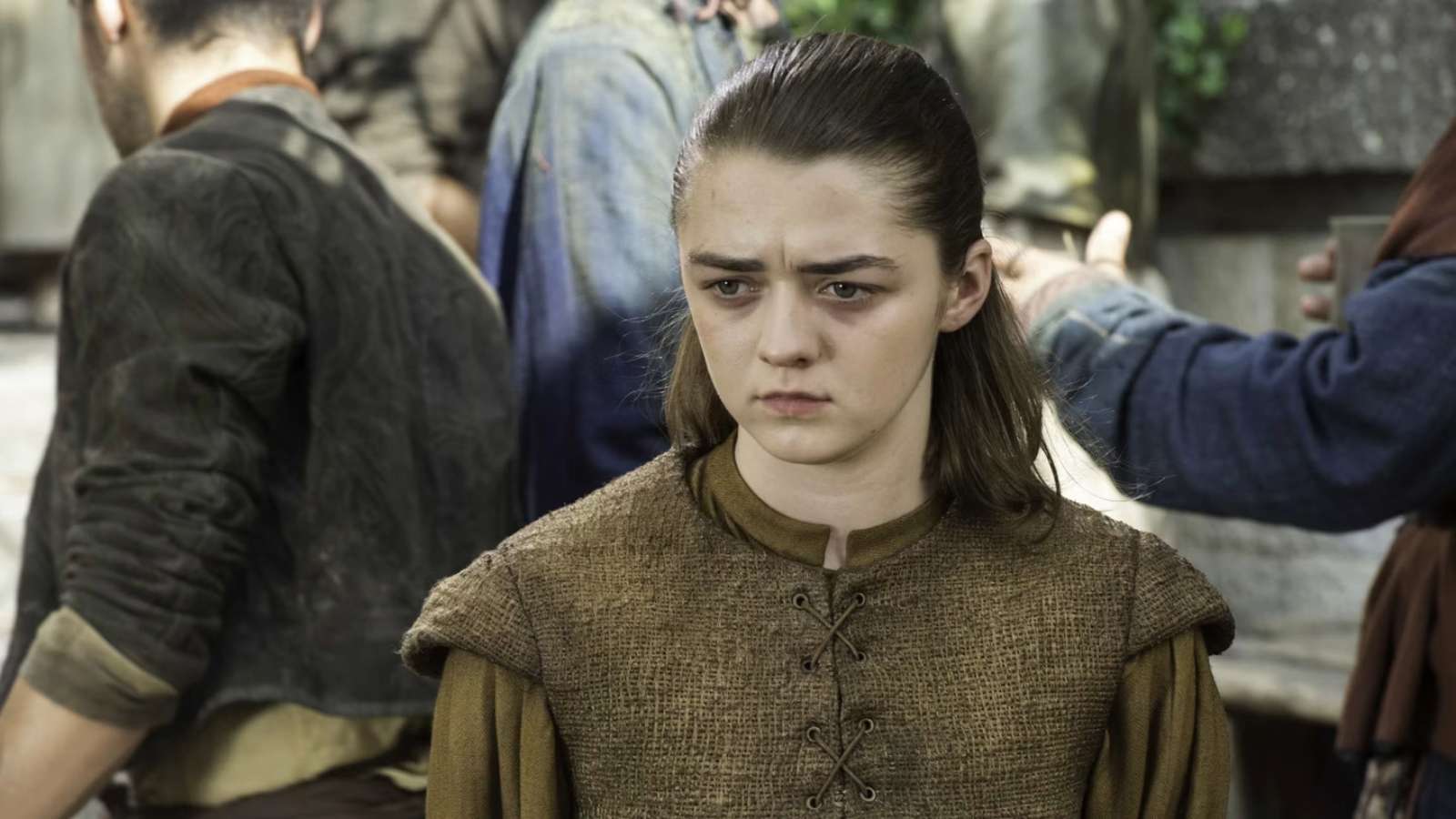 Maisie Williams as Arya Stark in Game of Thrones standing in a crowd