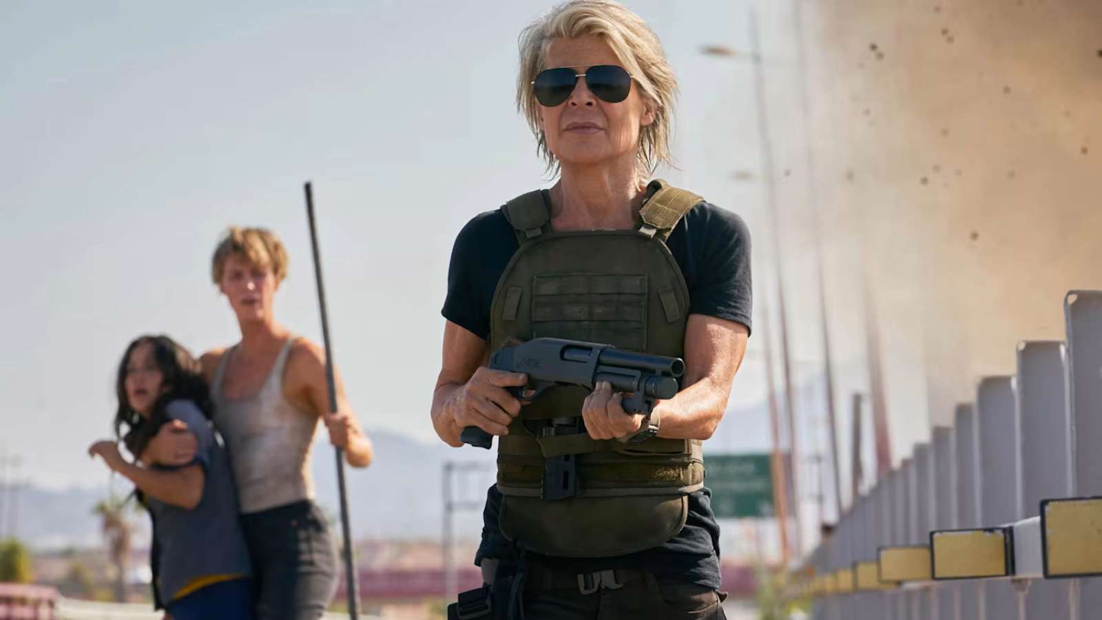 Linda Hamilton in Terminator: Dark Fate holding a gun and wearing sunglasses