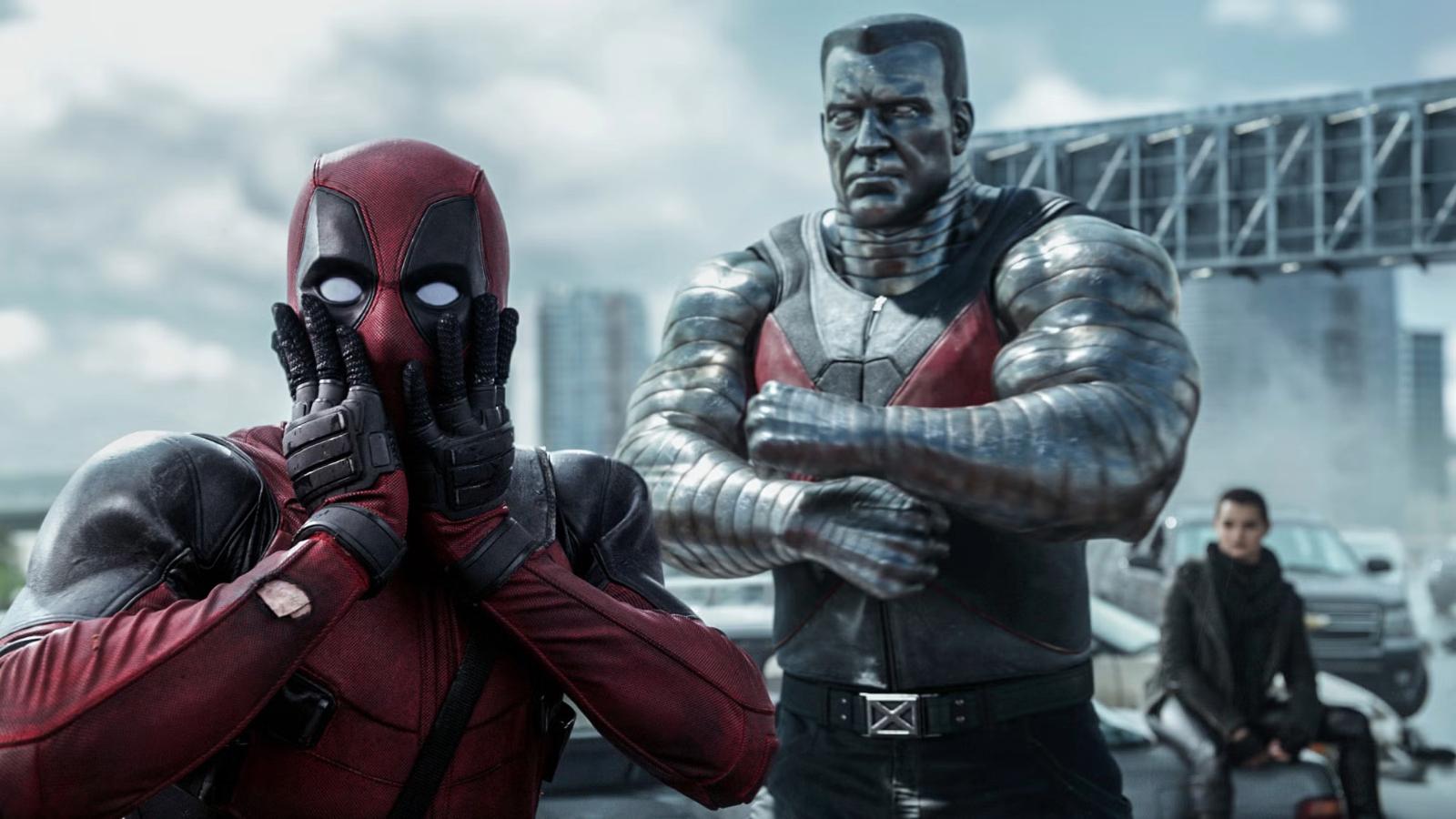 Deadpool and Colossus standing on a bridge in the Deadpool movie, with Deadpool's hands over his face