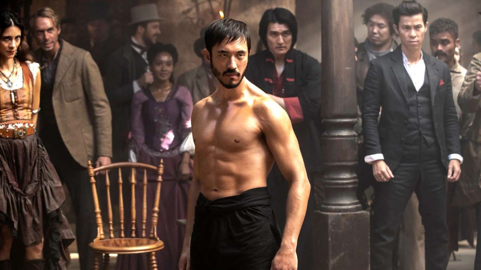 Andrew Koji as Ah Sahm in Warrior, standing in front of onlookers in a room