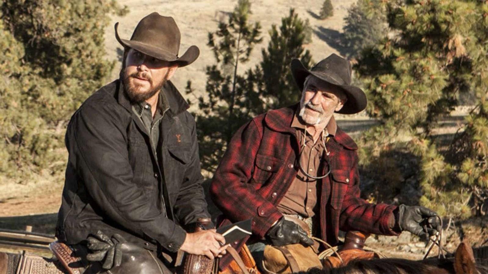 Cole Hauser as Rip and Forrie J. Smith as Lloyd on Yellowstone, sitting on horses and looking to the side