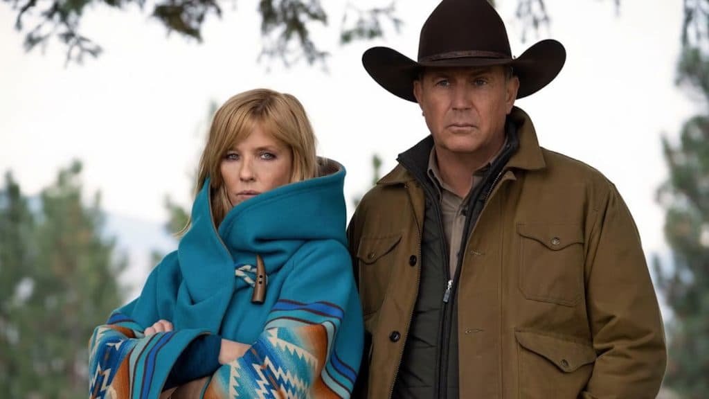 Yellowstone: Beth wearing a blue coat, standing next to John wearing a cowboy hat
