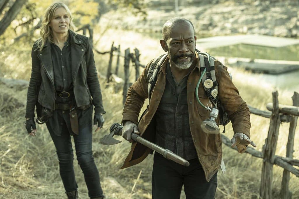 Fear The Walking Dead: Morgan and Madison walk across a path in the woods, Morgan holds a stick