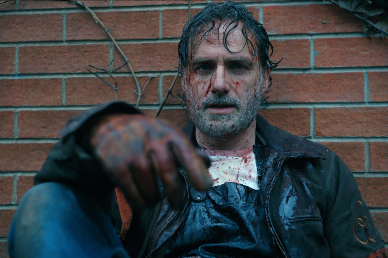 The Walking Dead: Rick sitting against a brick wall, covered in blood