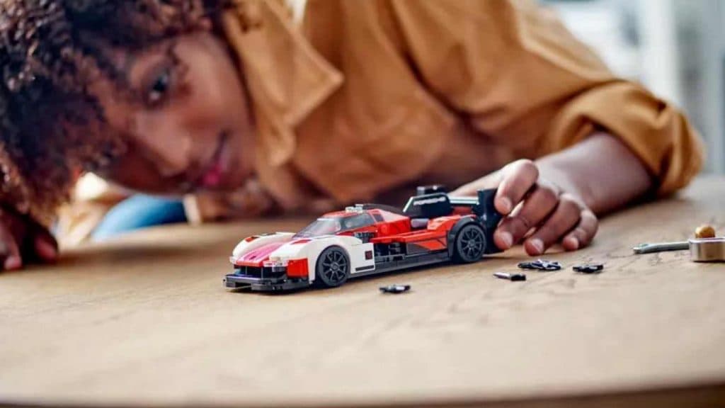 A child with their LEGO Speed Champions Porsche 963