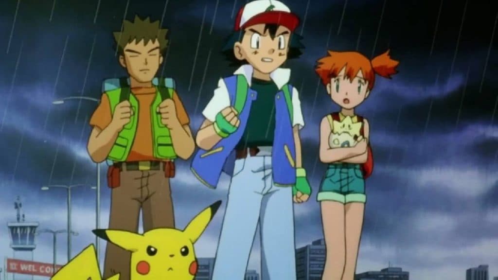 Ash, Brock, Misty, and Pikachu, stand in a determined pose in a dark rainy area