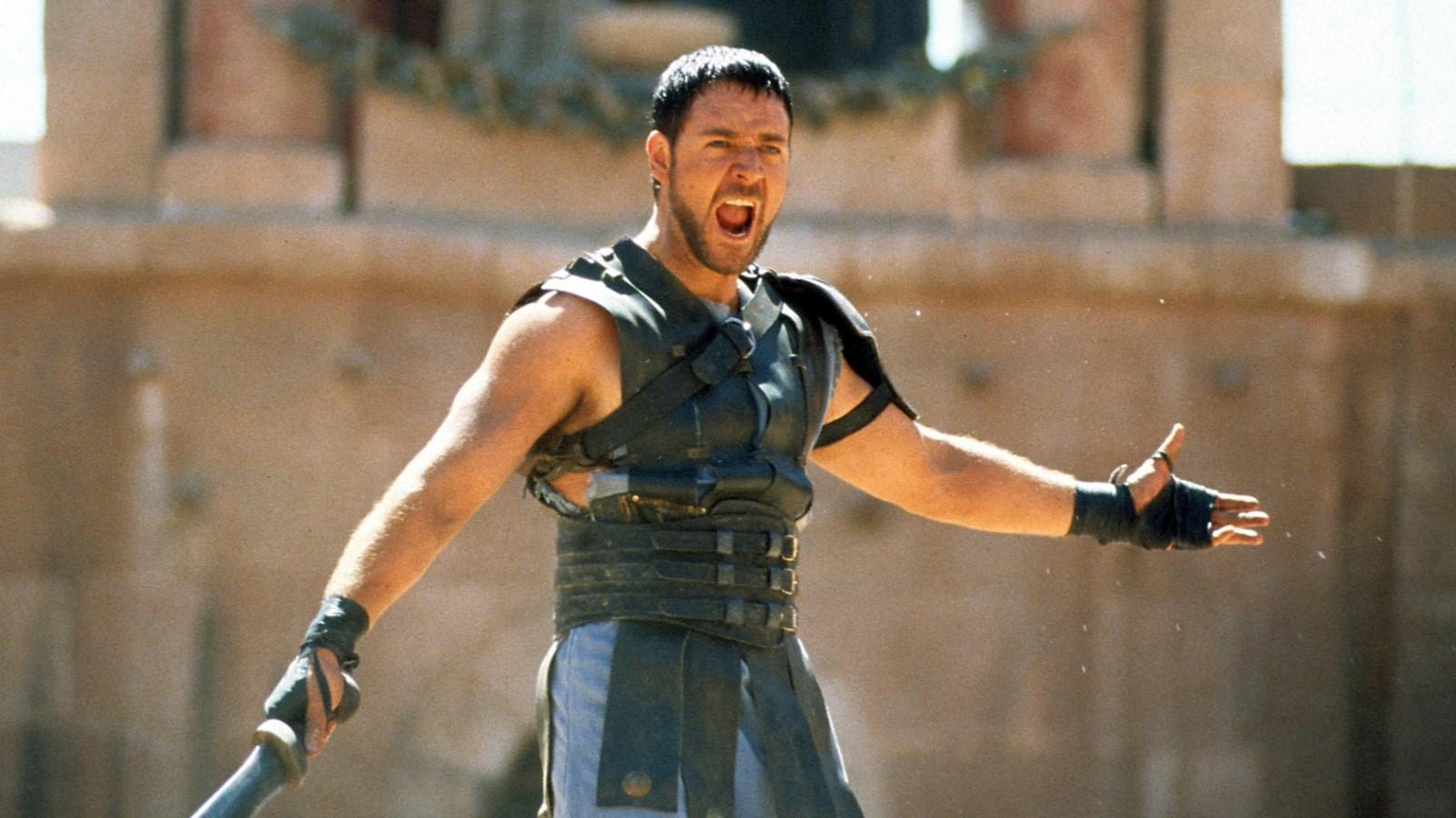 Russell Crowe as Maximus in Gladiator 2, standing in front of a crowd and yelling