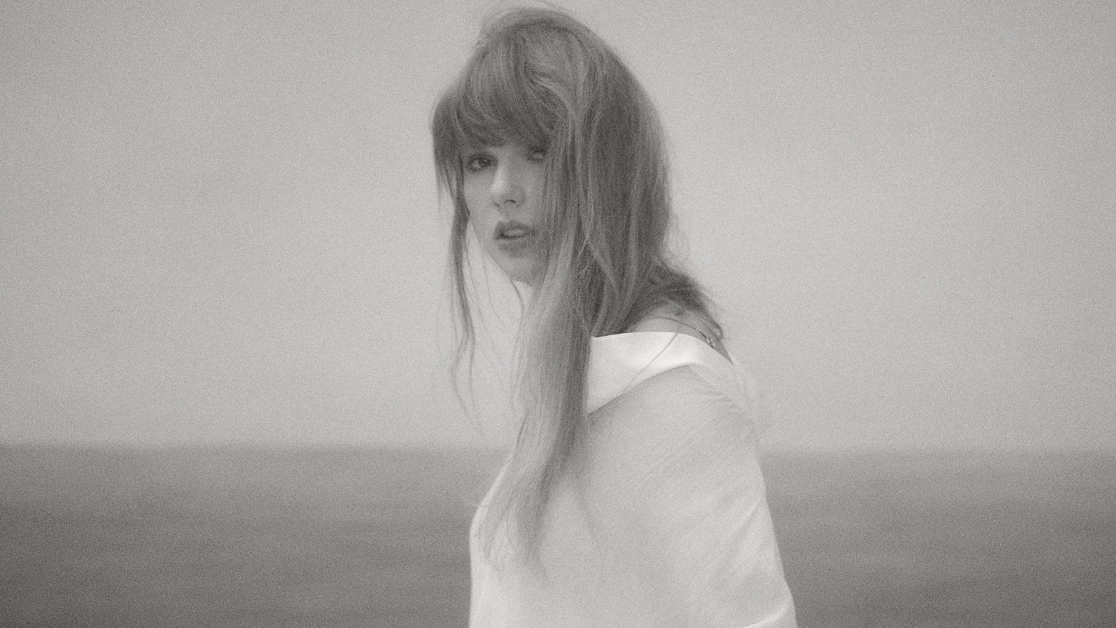 Taylor Swift in black and white overlooking a body of water