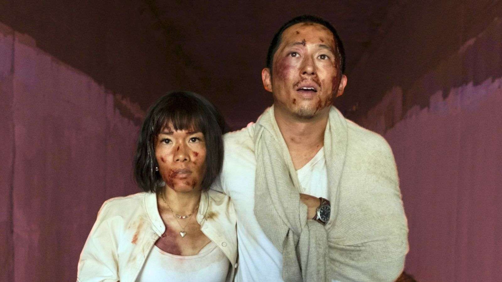 Ali Wong and Steven Yeun in Beef Season 2. They stand huddled in a tunnel, bruised and bleeding in dirty clothes.