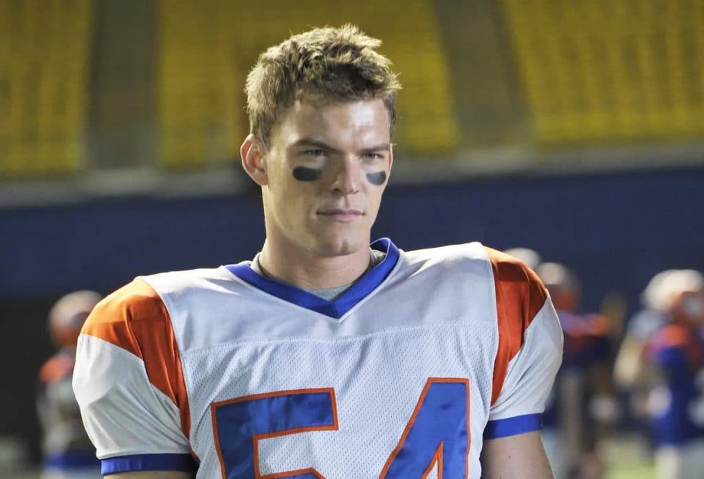 Alan Ritchson as Thad in Blue Mountain State, wearing a football jersey