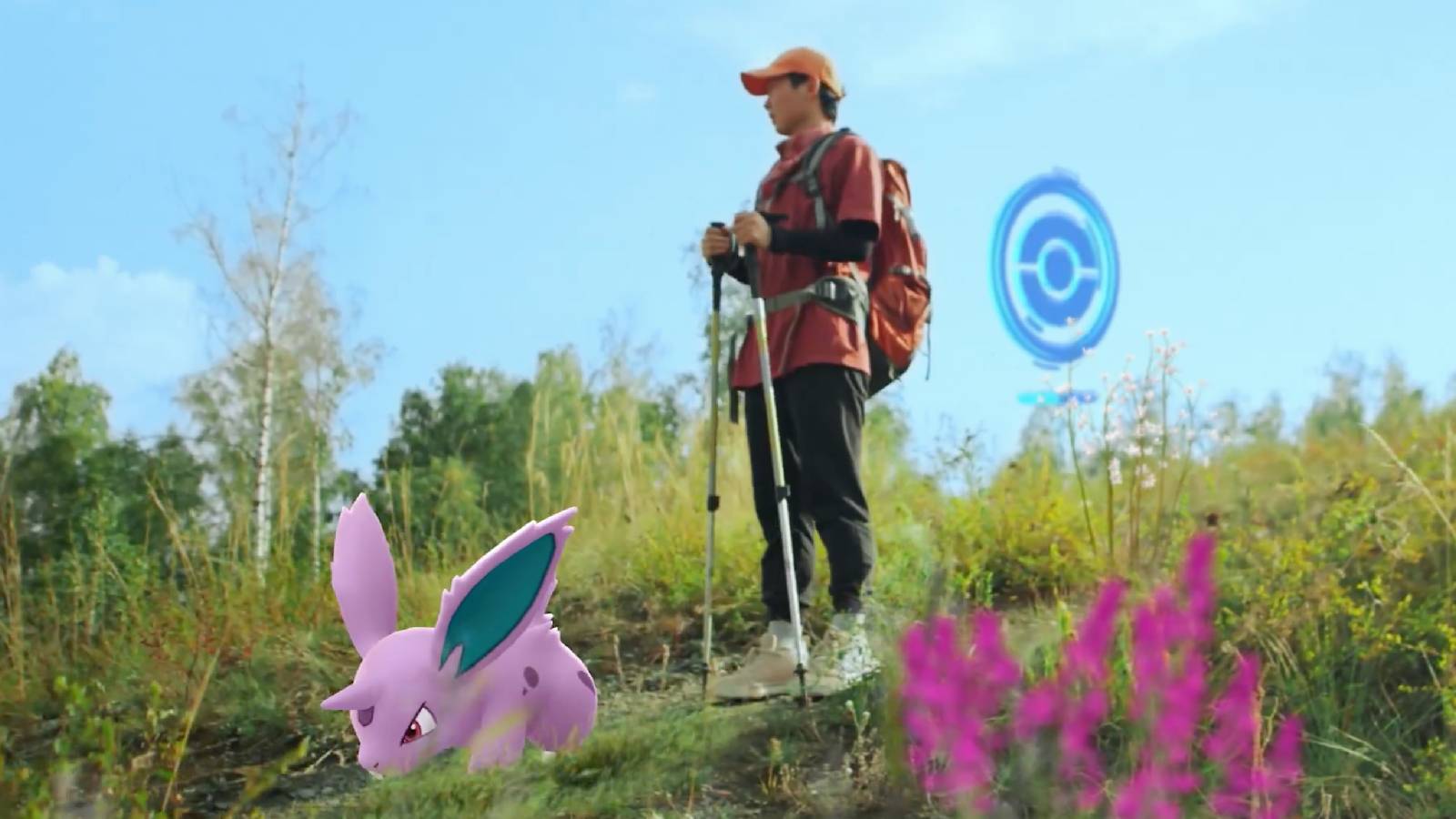 A Pokemon trainer stands on a hill with a male Nidoran