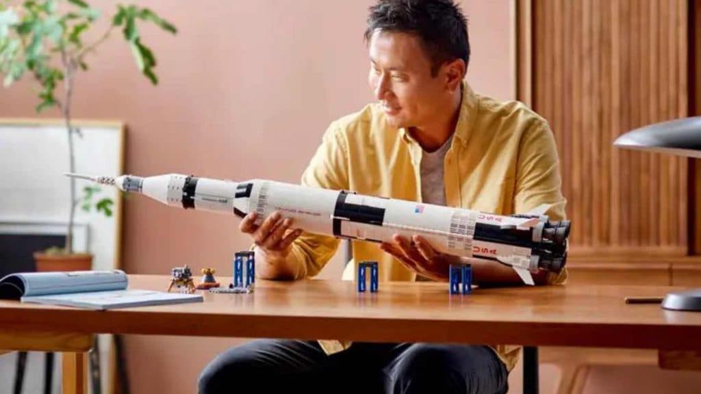 An adult admiring their LEGO Ideas NASA Apollo Saturn V set