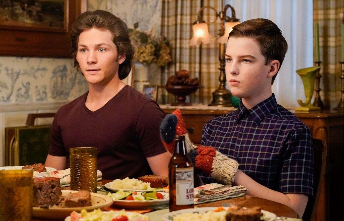 Georgie and Sheldon at the dinner table in Young Sheldon.