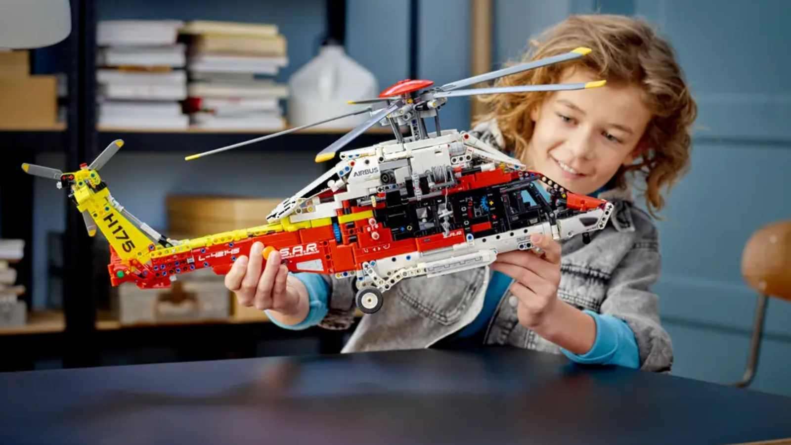 A child with their LEGO-reimagined Airbus H175 Rescue Helicopter
