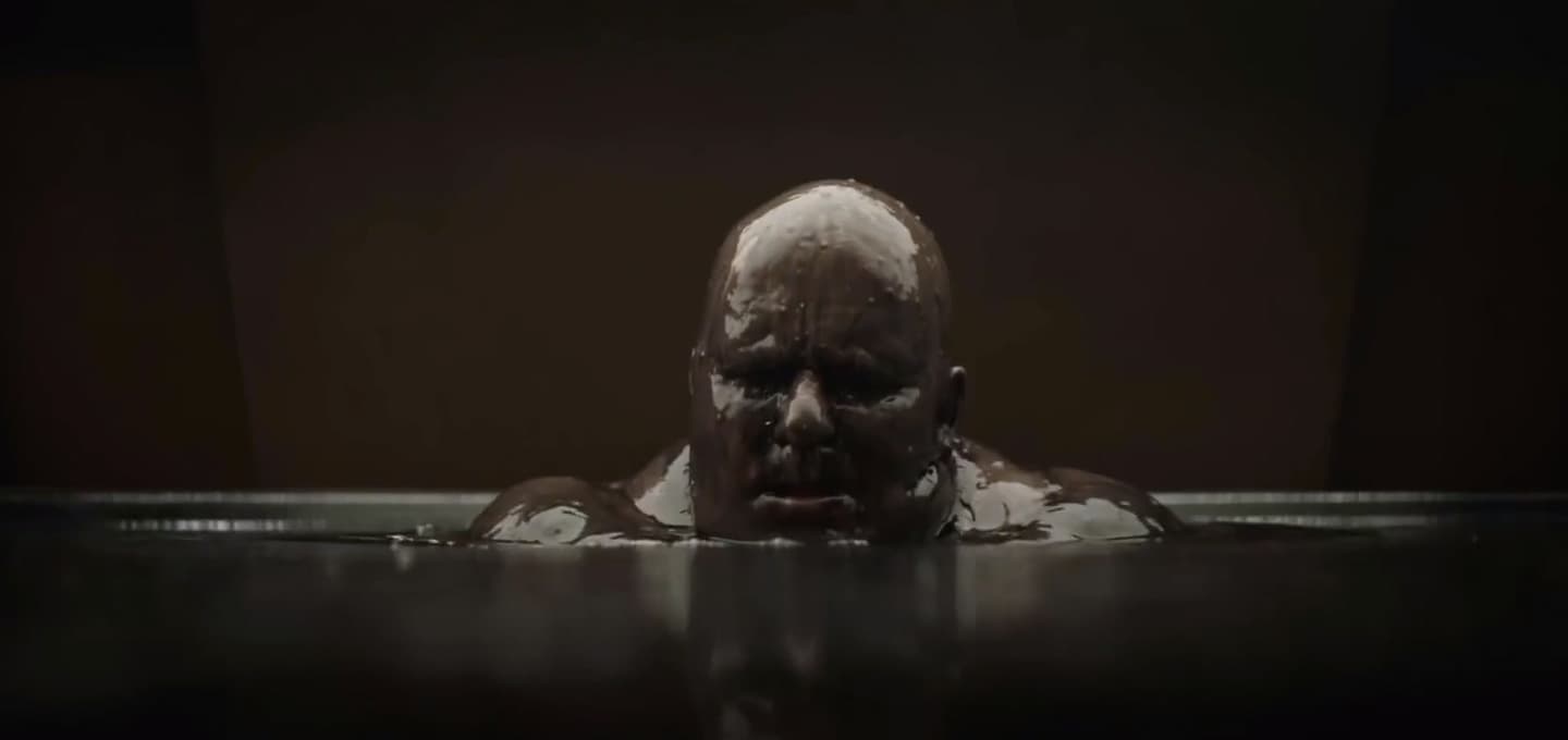 Stellan Skarsgard as Baron in Dune. He sits in inky black liquid.