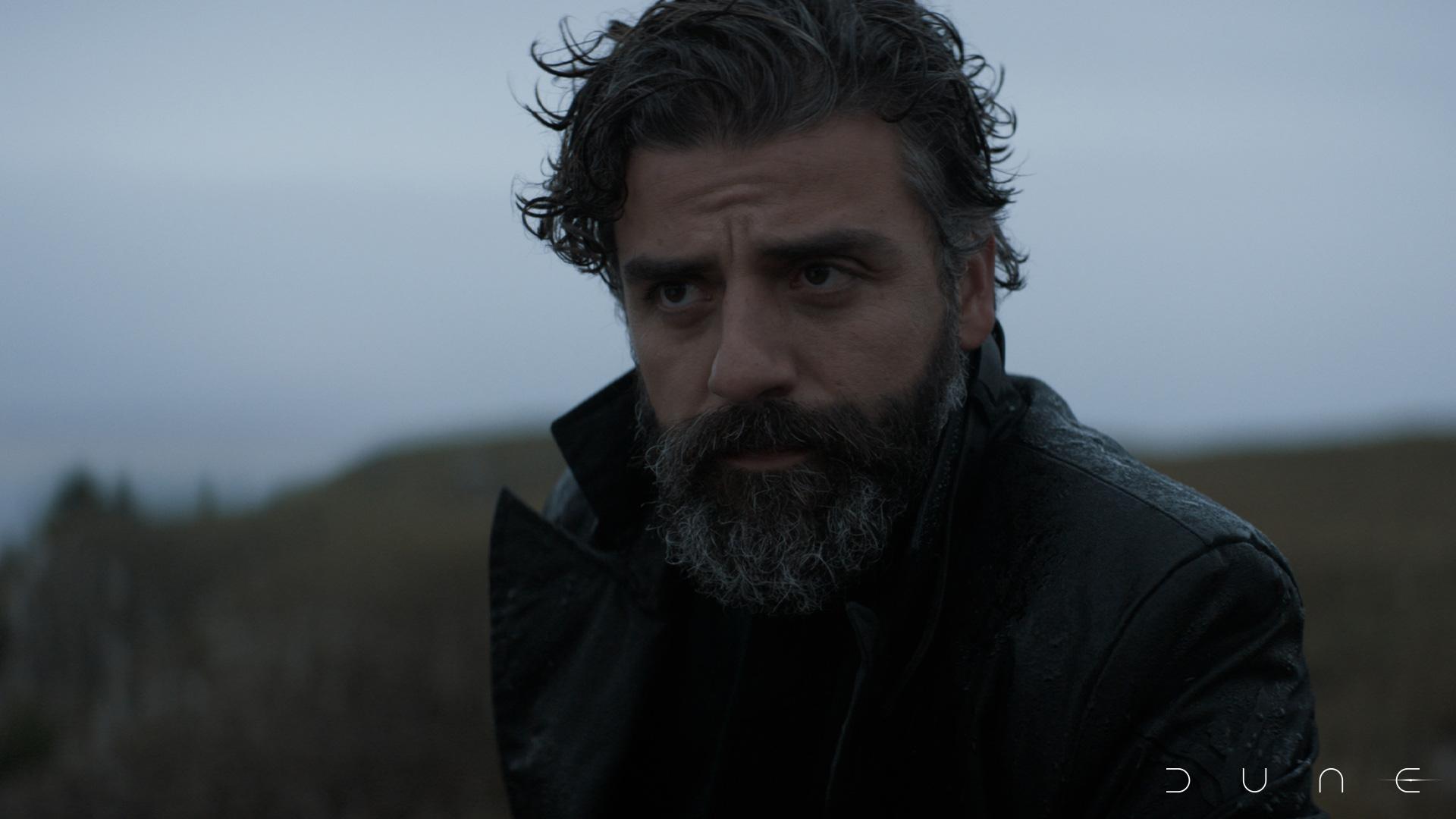 Oscar Isaac as Leto Atreides in Dune. He stands on a cold open landscape.