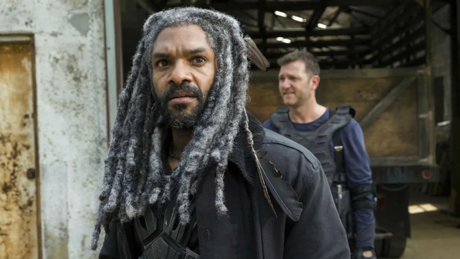 Khary Payton as Ezekiel on The Walking Dead, standing outside of a warehouse