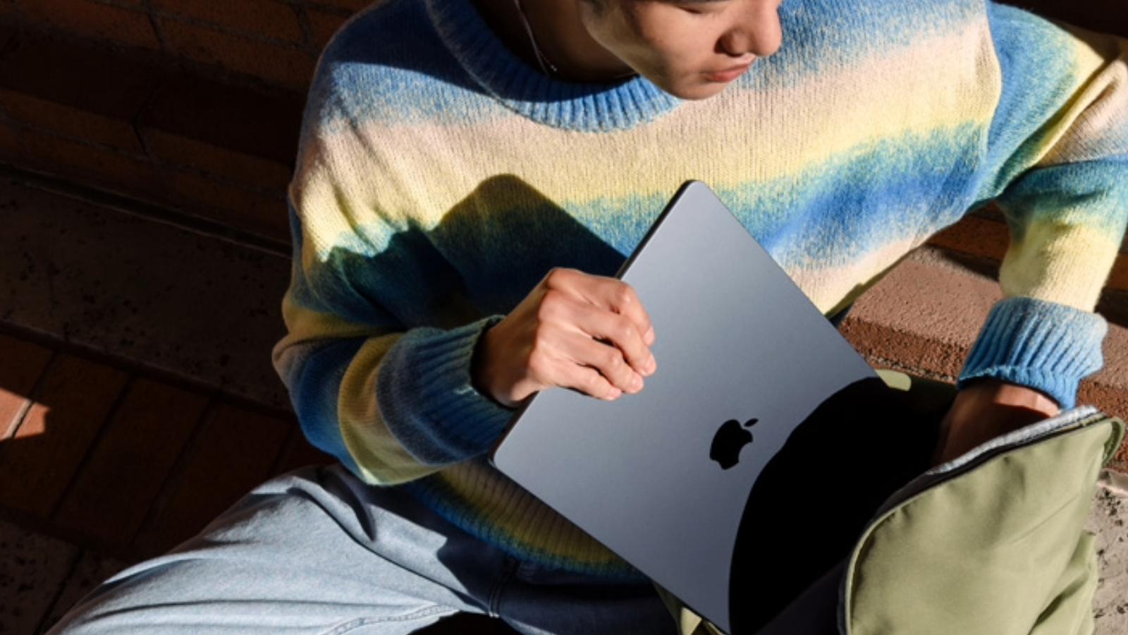 Apple M3 MacBook Air being held by a user