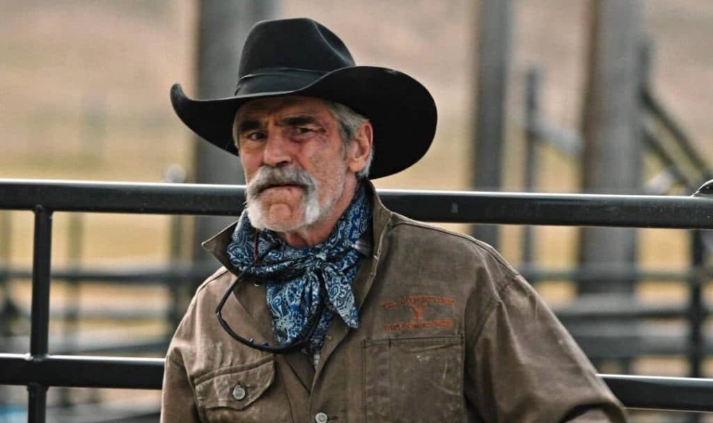 Forrie J. Smith as Lloyd on Yellowstone, standing in a pen and looking concerned