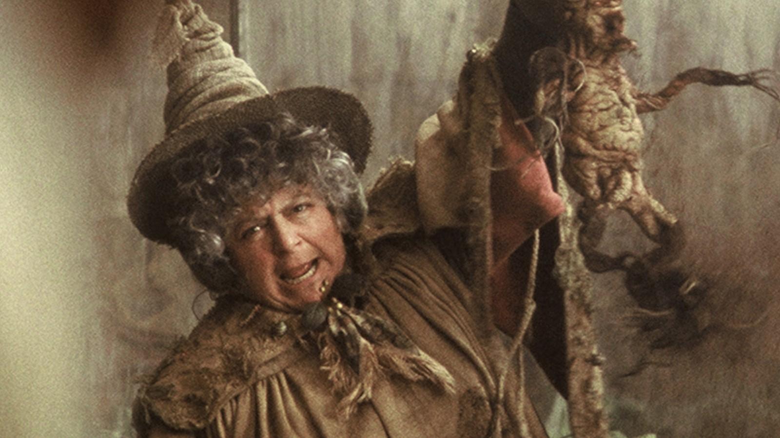 Miriam Margolyes as Professor Sprout in Harry Potter, holding up a plant