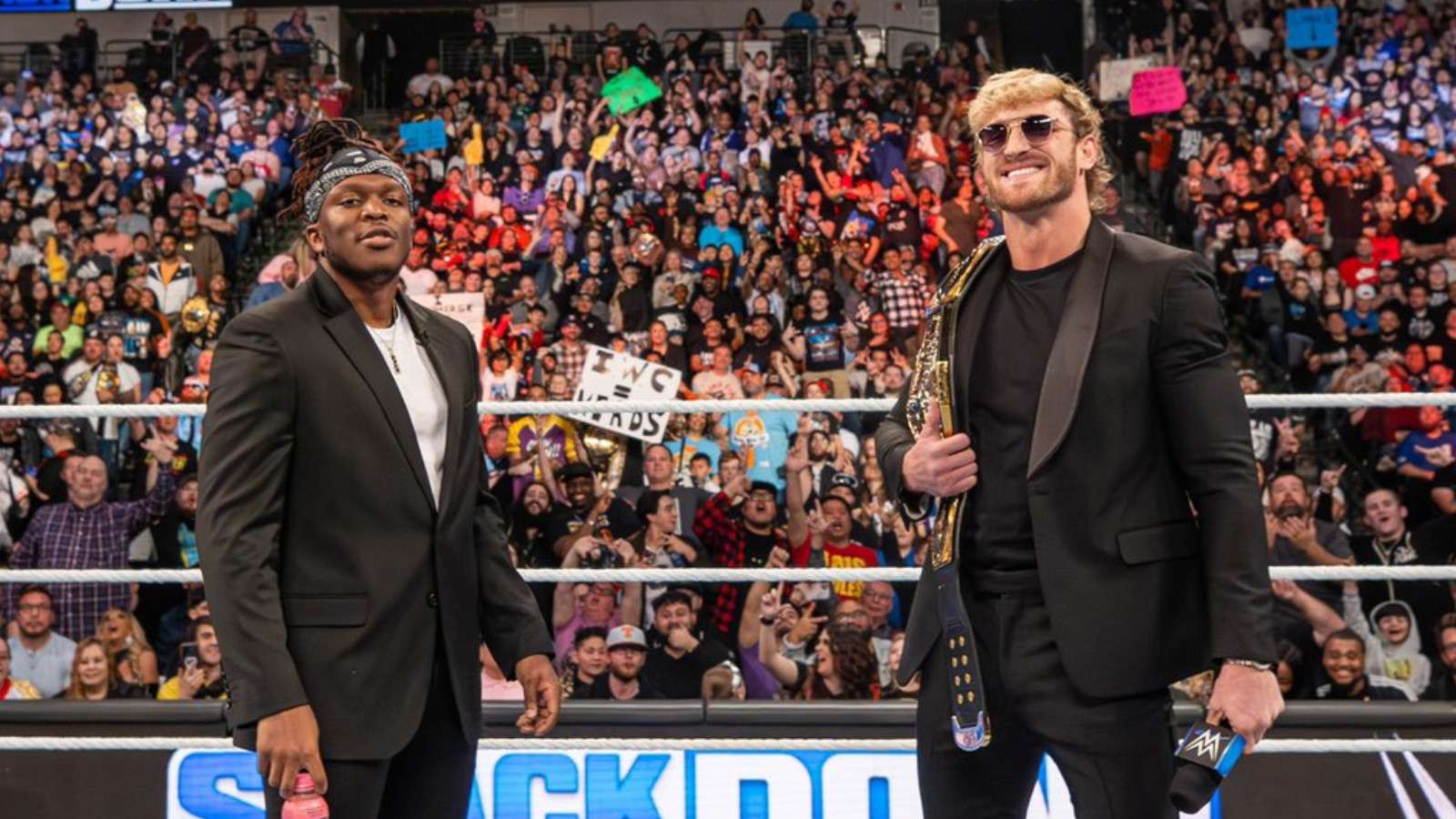 KSI and Logan Paul standing in WWE ring holding Prime Hydration bottle