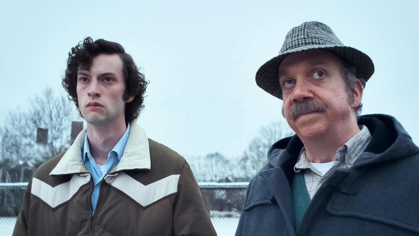Paul Giamatti and Dominic Sessa in The Holdovers, standing in the snow