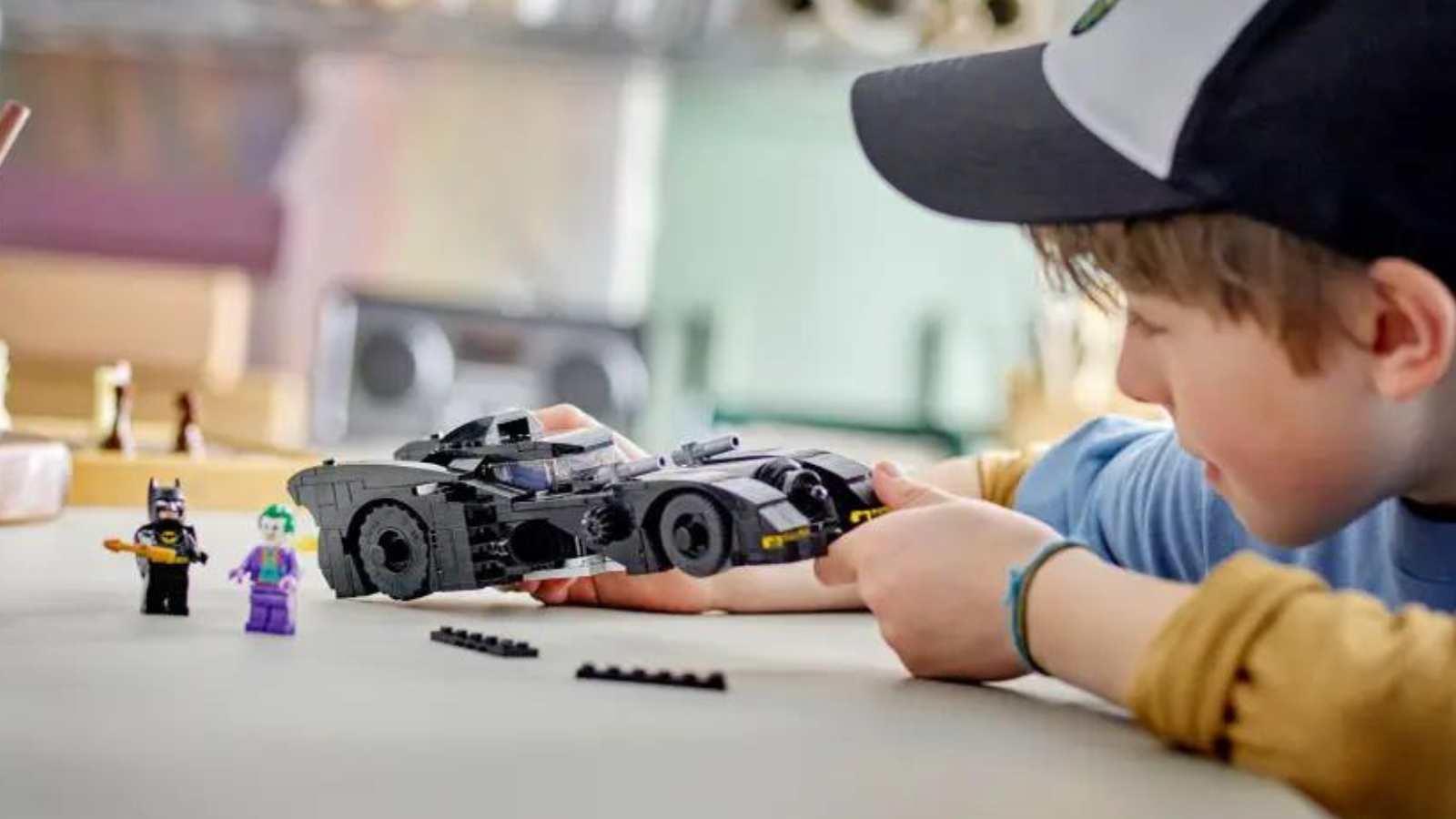 A child with their LEGO Batmobile: Batman vs. The Joker Chase set