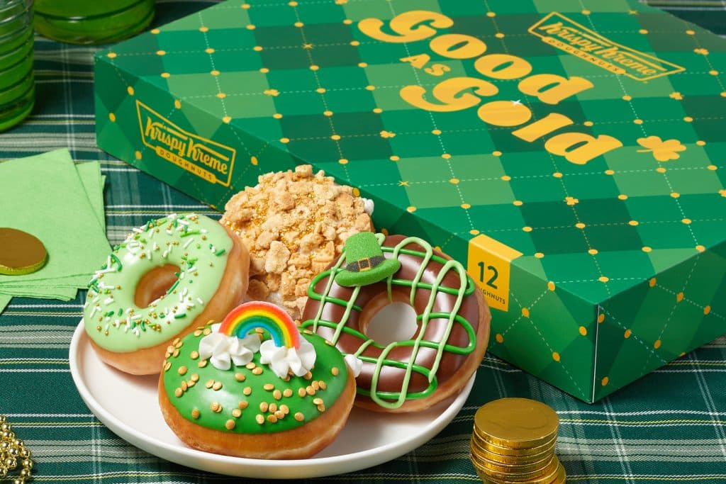 A photo of four St Patrick's Day themed donuts with a green box in background