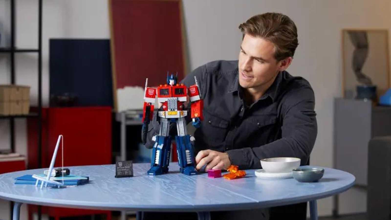 An adult with their LEGO Icons Optimus Prime set