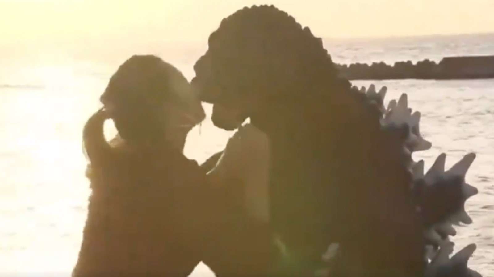 Girl kisses Godzilla on date.