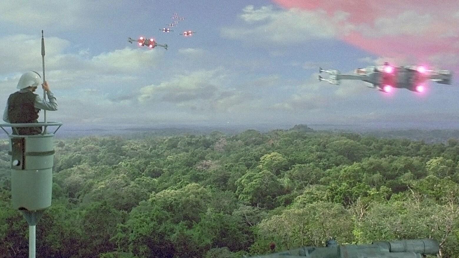 A Rebel guard watches X-Wing Starfighters take off on Yavin 4 in Star Wars A New Hope.