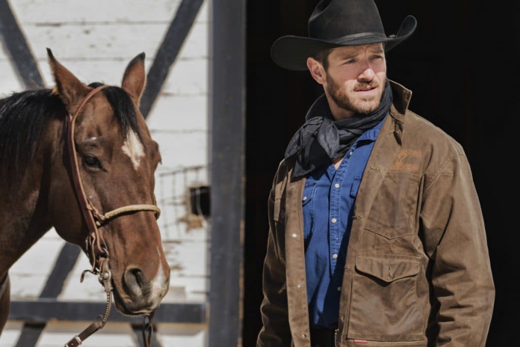 Ian Bohen as Ryan on Yellowstone, standing next to a horse
