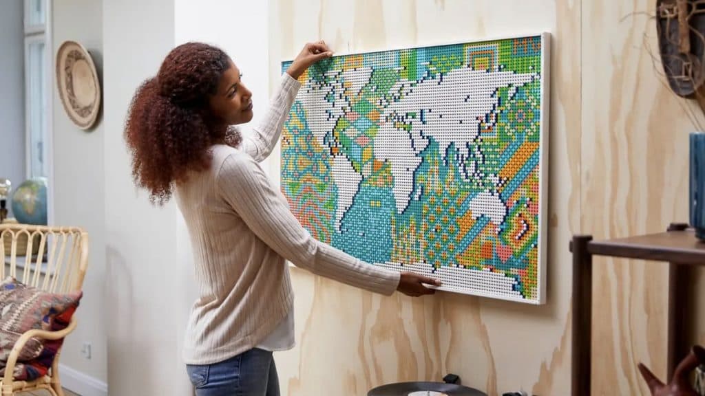 An adult hanging up their LEGO Art World Map