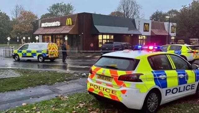 a photo of some police cars outside a cordoned off McDonald's restaurant