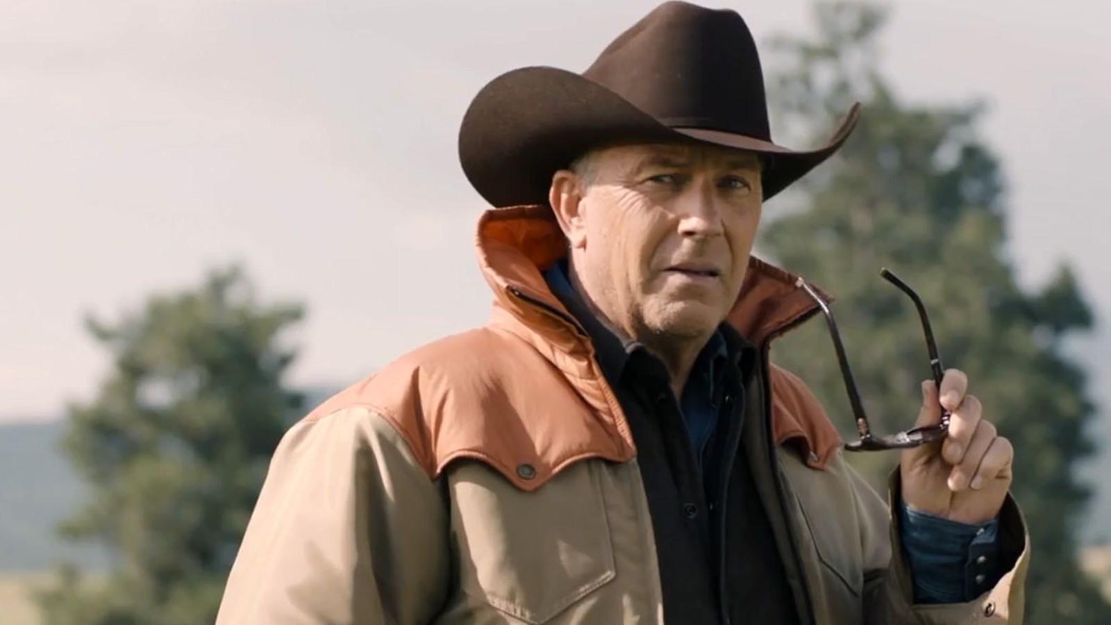 Kevin Costner as John Dutton in Yellowstone, holding his sunglasses
