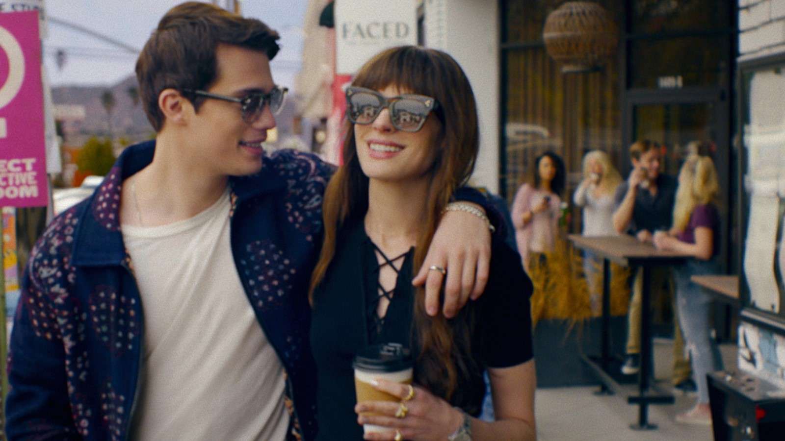 Anne Hathaway and Nicholas Galitzine as Sophie and Hayes in The Idea of You, walking down the street