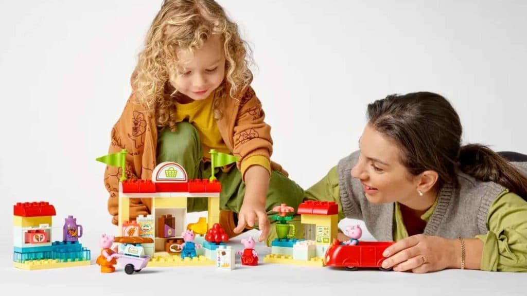 A child and an adult with the LEGO Duplo Peppa Pig Supermarket set