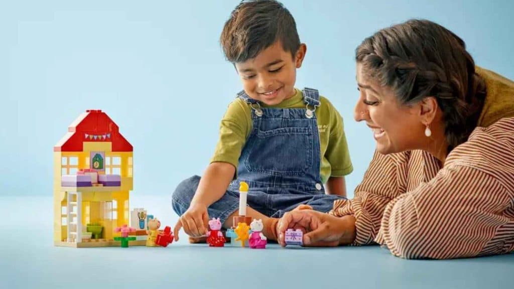 A child and an adult with the LEGO Duplo Peppa Pig Birthday House set
