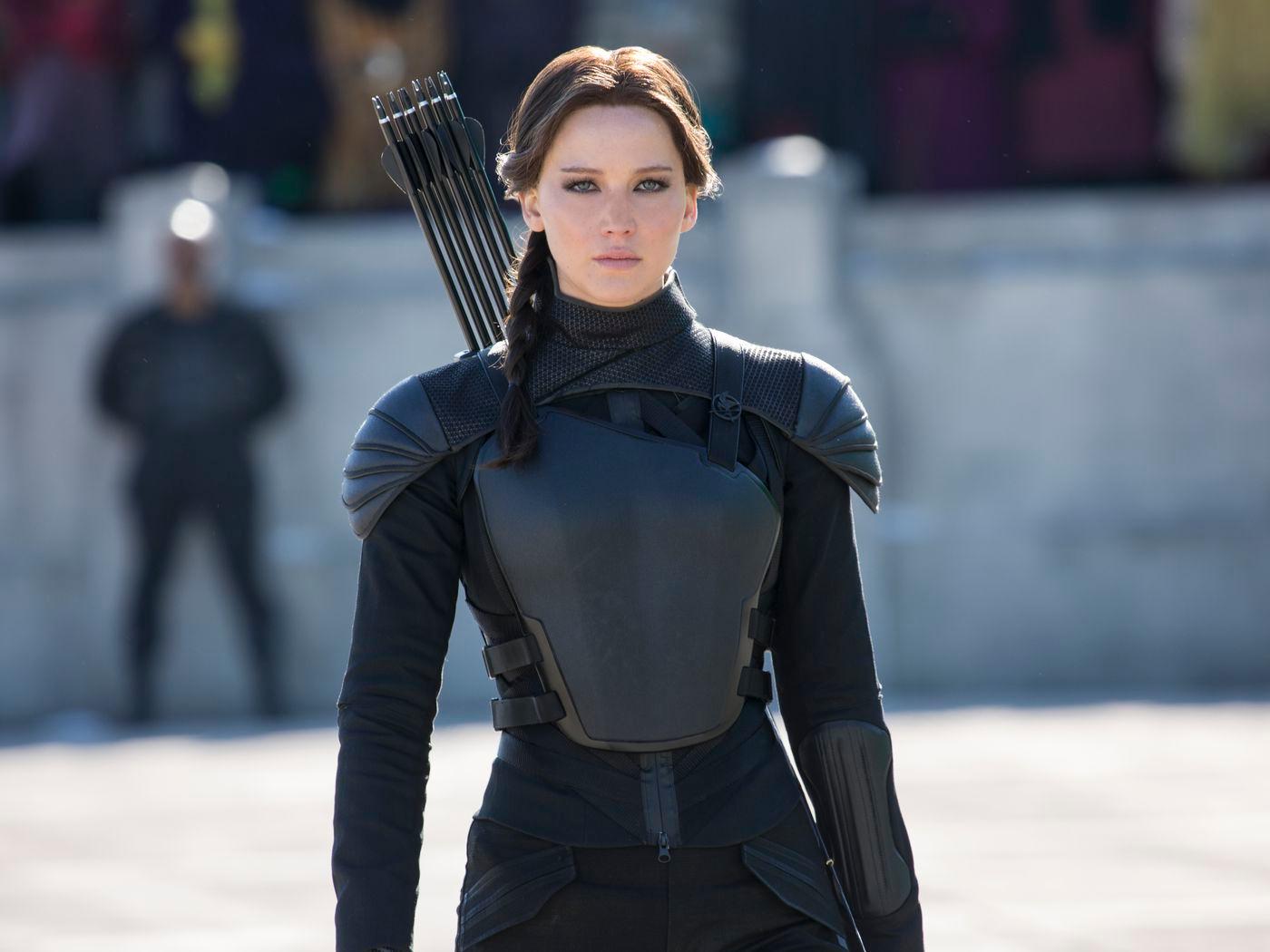 Jennifer Lawrence as Katniss Everdeen in The Hunger Games: Mockingjay Part 2. She is dressed all in black, wielding a bow and arrow.