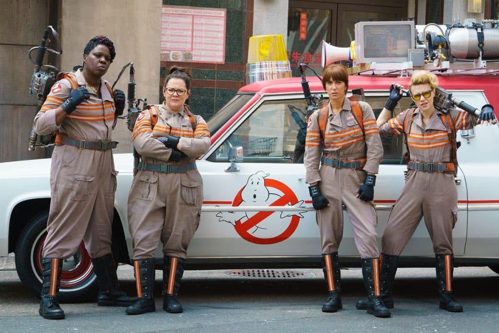 Leslie Jones, Melissa McCarthy, Kristen Wiig, and Kate McKinnon stand in their Ghostbusters uniforms in the 2016 film.