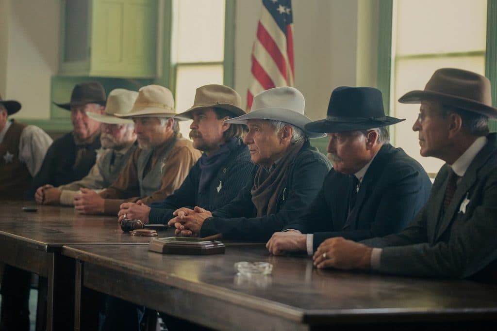 Yellowstone 1944 release date: a group of cowboys sitting behind a table in Yellowstone 1923
