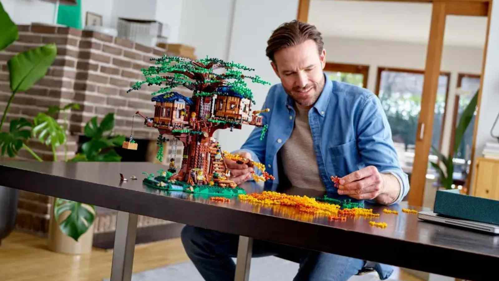 An adult with their LEGO Ideas Tree House