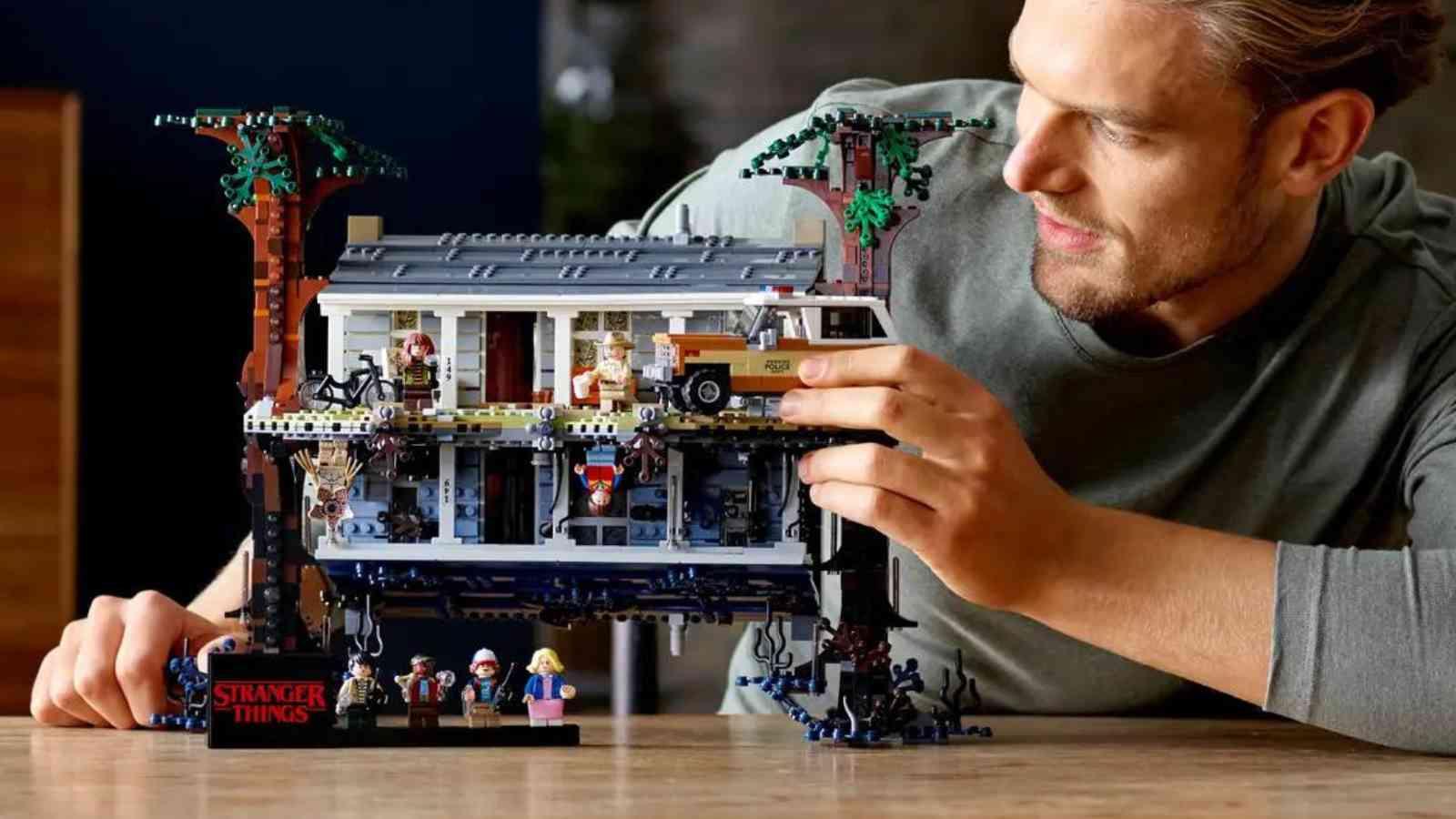 An adult with their LEGO Stranger Things The Upside Down set
