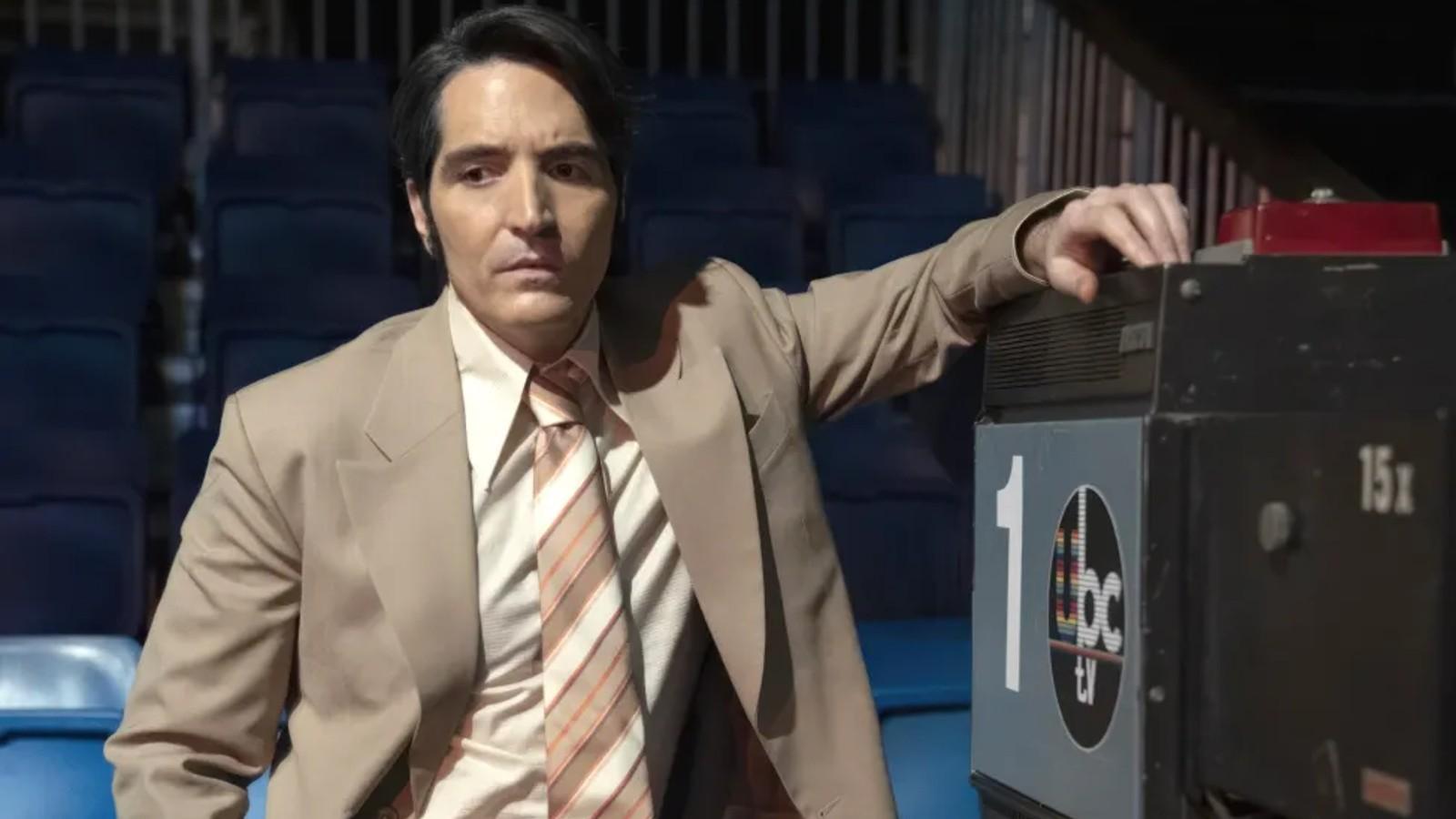 David Dastmalchian leans against a camera in Late Night with the Devil.