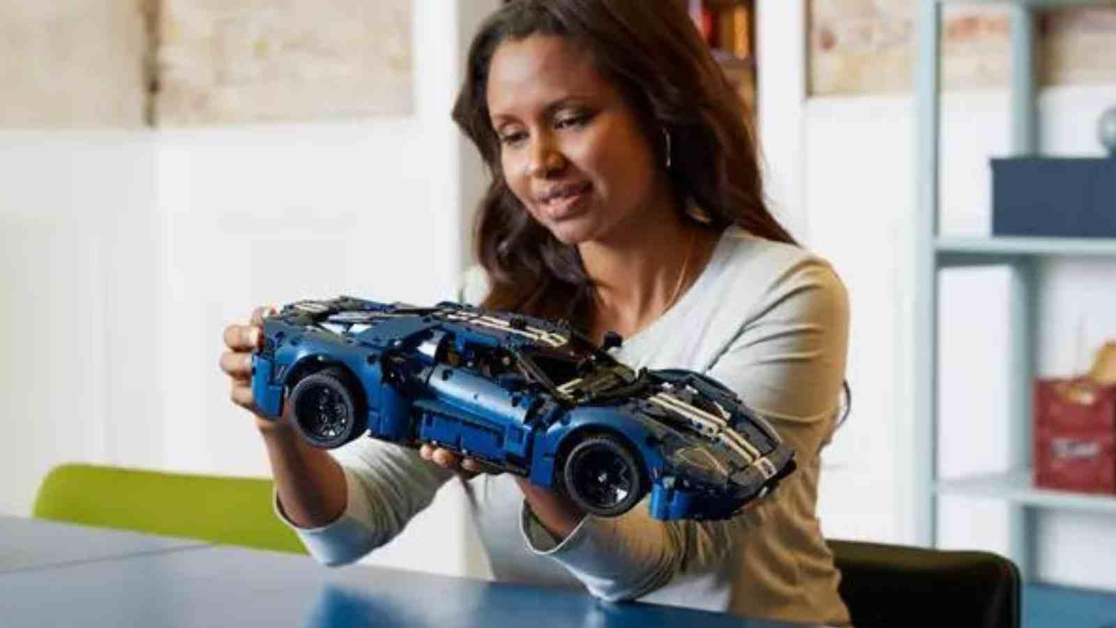 An adult with their LEGO Technic Ford GT