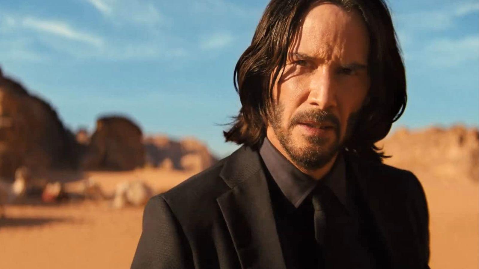 Keanu Reeves as John Wick in Chapter 4. He stands in the desert.