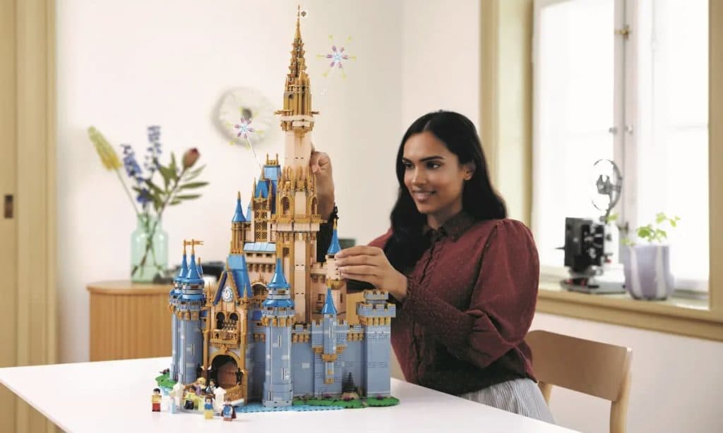 An adult with the LEGO Disney Castle