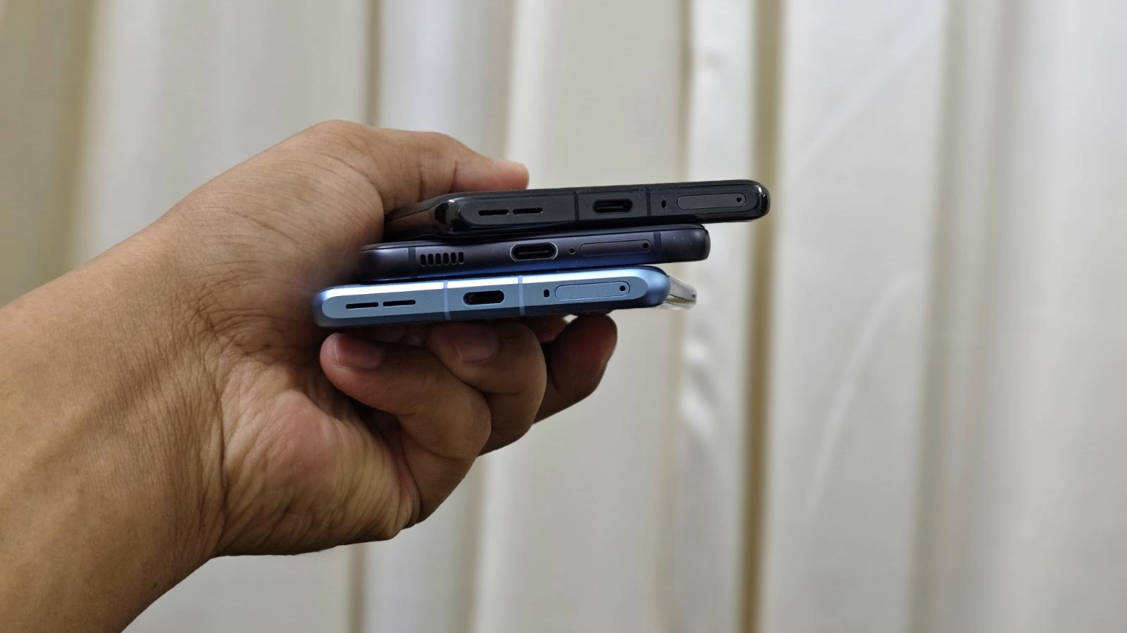Image shows three smartphones on top of each with their charging port visible.